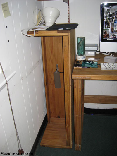 The side of a This End Up computer desk with the shelf sideways on the floor between the desk and the wall