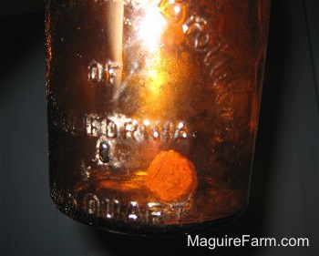 Close Up - a brown bottle being held in the air showing the cork inside