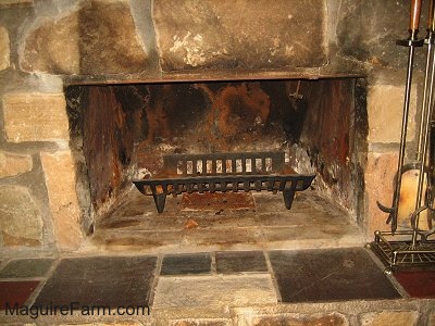 The opening of a fireplace with a wood rack inside of it