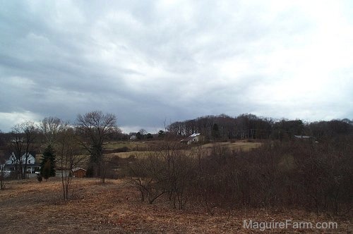 A range of field. There are homes and barns scattered through the photo